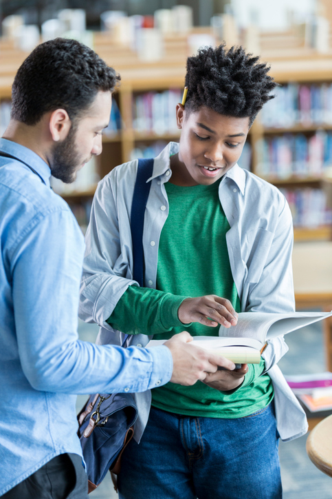 Male high school student asks teacher question